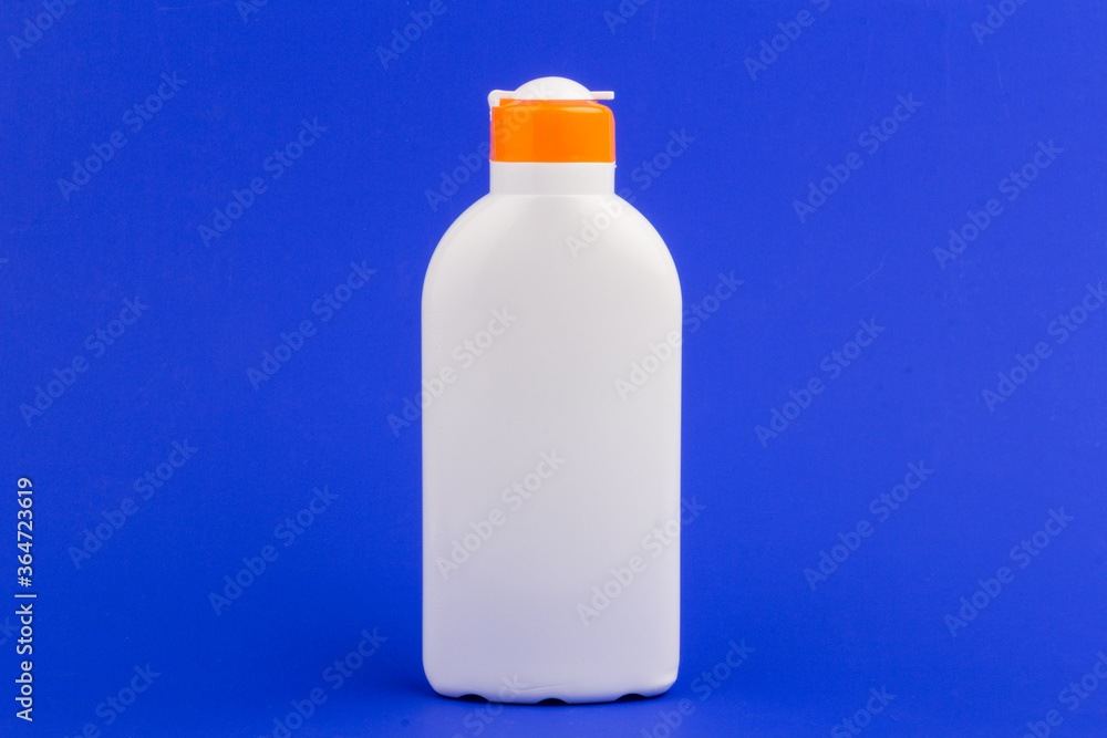 Sunscreen bottle on blue background. Health concepts and skin care Sunscreen bottle on blue background. Health concepts and skin care
