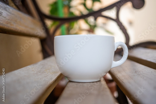 Hot coffre in coup on old Woods table with blur nature background.