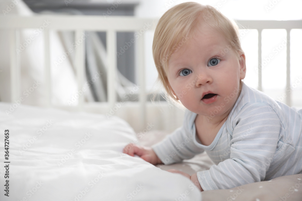 Adorable little baby lying in comfortable crib Adorable little baby lying in comfortable crib