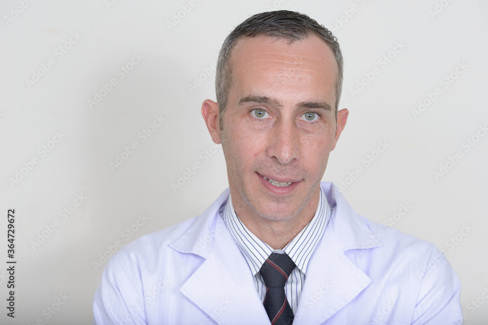 Portrait of mature handsome man doctor against white background Portrait of mature handsome man doctor against white background