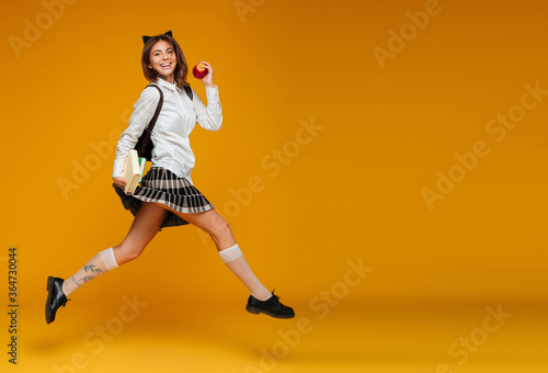 Full length portrait of a cheerful schoolgirl in uniform