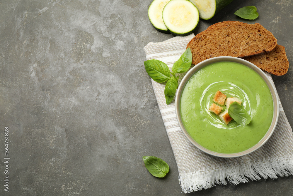 Tasty homemade zucchini cream soup served on grey table, flat lay. Space for text Tasty homemade zucchini cream soup served on grey table, flat lay. Space for text