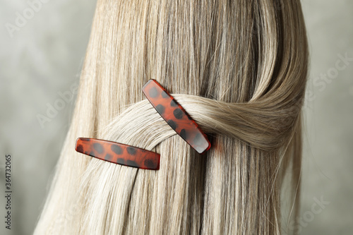 Photos Young woman with beautiful hair clips on grey background, closeup