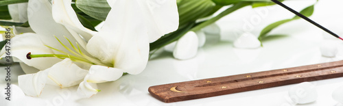 aroma stick on wooden stand near lily on white background  panoramic shot