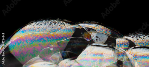 Coloful soap bubbles on black background isolated. Macro shot for design