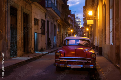 Amazing old american car on streets of Havana with Capitolio Building in background during night. Havana, Cuba.
