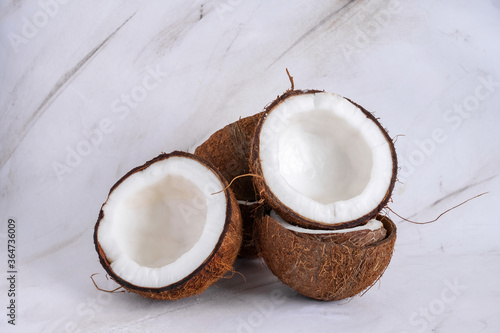 stack of halved coconuts on a marble background copy space