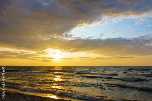 Sunset over the sea. Reflection of sunlight in the sea waves. The sky in the sunset rays.