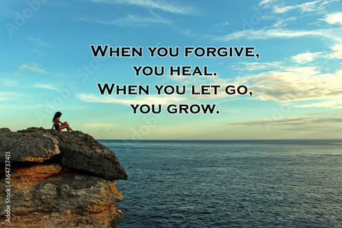 Inspirational quote - When you forgive, you heal. When you let go, you grow. On blurry background of bright blue sky over horizon and a young woman sitting alone on rock against ocean view.