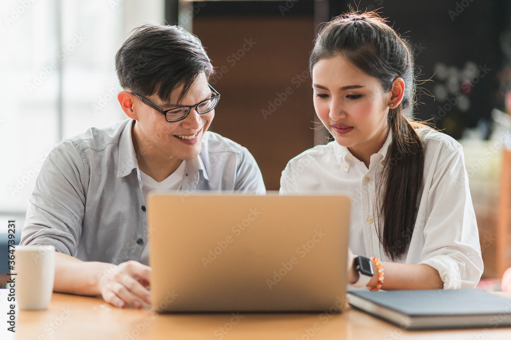 Obraz premium Asian business people man and woman conference talking and working with laptop together. Young couple work at home.
