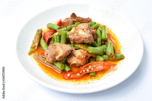 spicy fried pork bone with slice yard long bean in curry sauce on plate 