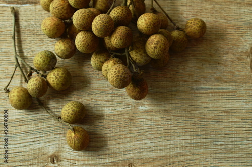 Longan tropical fruit in branch on wooden table