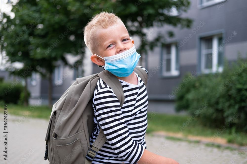 back to school. Happy Boy wearing mask and backpacks protect and safety from coronavirus. Child going school after pandemic over. Looking at camera students are ready for new school year. back to school. Happy Boy wearing mask and backpacks protect and safety from coronavirus. Child going school after pandemic over. Looking at camera students are ready for new school year.