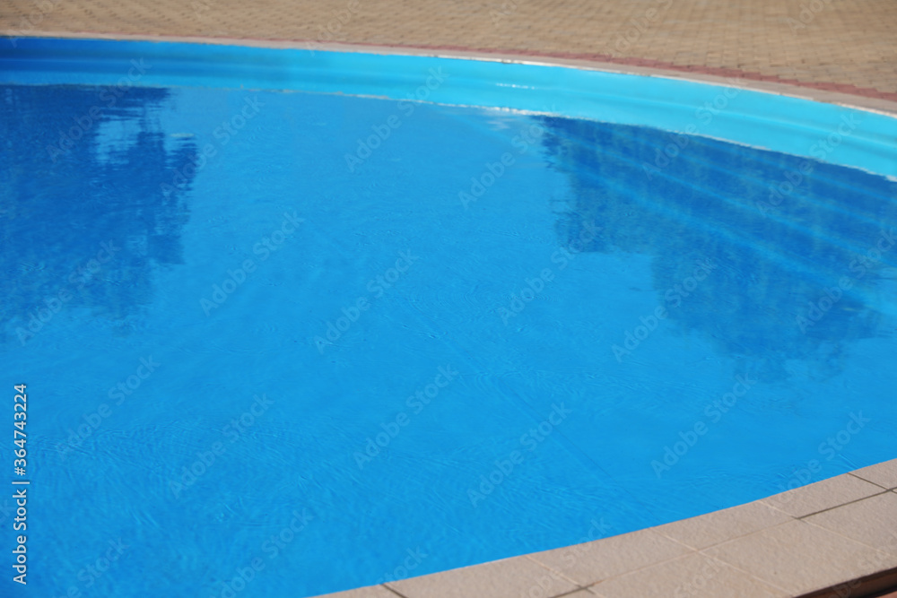 Outdoor swimming pool with clear water on sunny day. Summer vacation