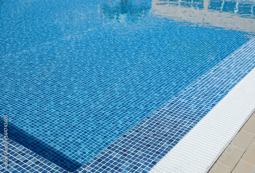 Outdoor swimming pool with clear water on sunny day. Summer vacation