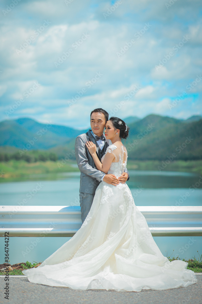 Prtrait of Asian bride and groom with beautiful landscape of dam and mountain