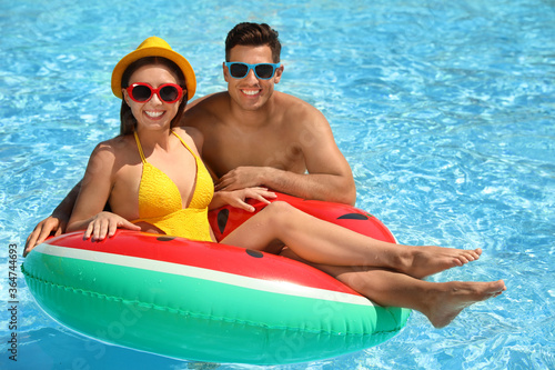Happy couple with inflatable ring in swimming pool. Summer vacation © New Africa