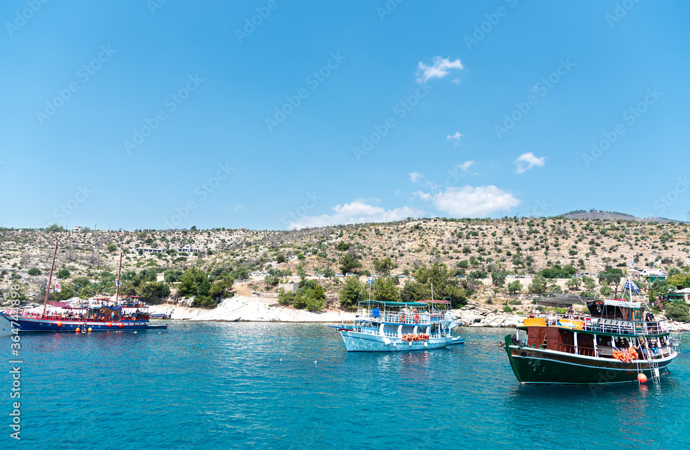 Waterfront view at beautiful bay in Greece with traditional boats. Touristic boat tour