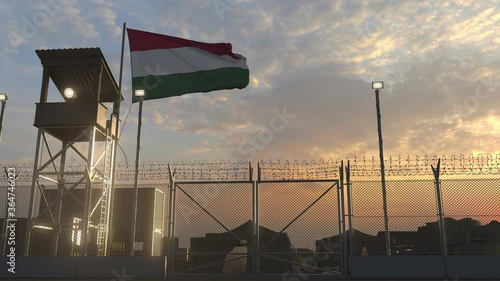 Flying flag of Hungary above military base in the evening photo