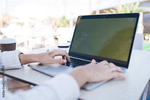 Selective focus on female hands typing program code during freelance job on modern laptop computer, cropped image of graphic designer creating web project during remote working on netbook technology