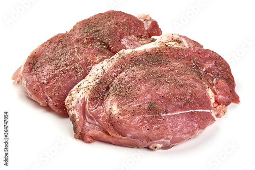 Raw pork steaks sprinkled with ground pepper, isolated on white background