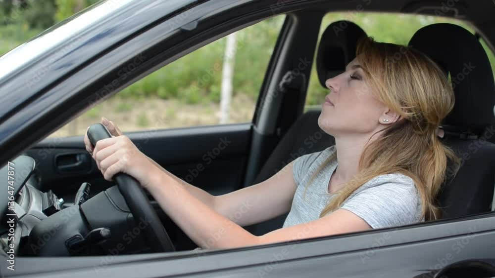Young charming girl is nervous in traffic jam driving a car Young charming girl is nervous in traffic jam driving a car