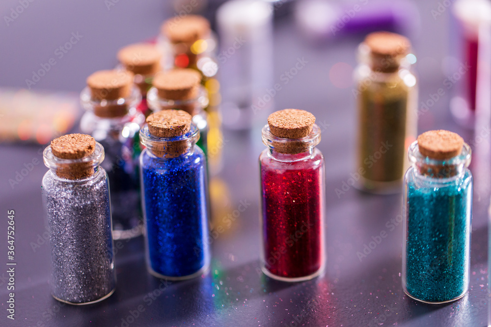party, decoration and holidays concept - set of different color glitters in small glass bottles with cork stoppers party, decoration and holidays concept - set of different color glitters in small glass bottles with cork stoppers