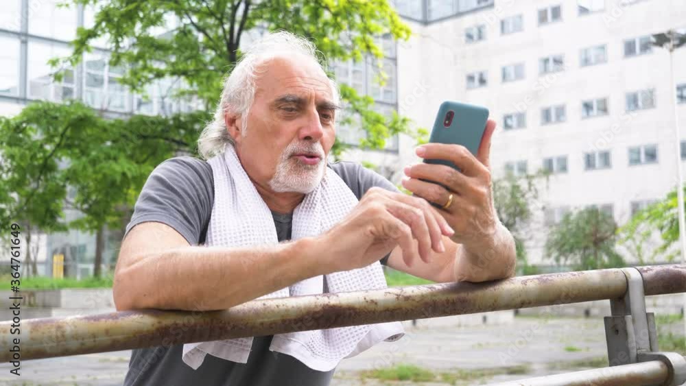 Senior athletic man using smartphone for video call