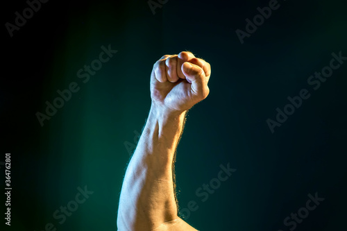 Fototapeta Naklejka Na Ścianę i Meble -  male hands with a clenched fist on a dark background