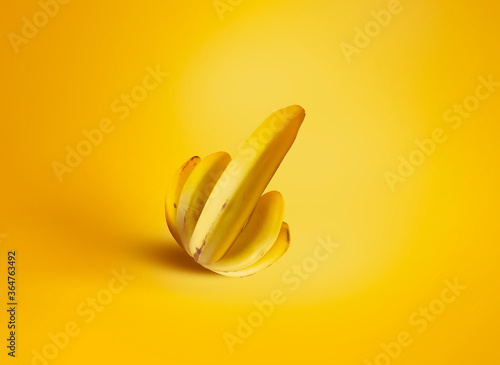 A bunch of bananas in the shape of a palm and thumb up on a yellow background. Creative concept