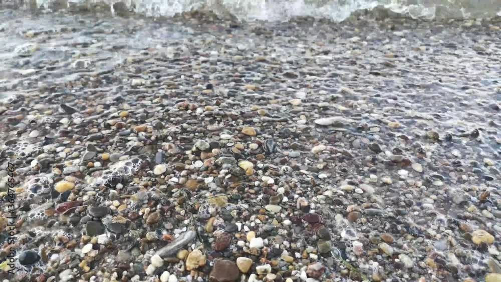 Calm waves of clear transparent river of Middle Rhine are lapping at shore covered with wet pebbles.Close up footage of crystal coastal water.Copy space, natural water horizontal background footage. Calm waves of clear transparent river of Middle Rhine are lapping at shore covered with wet pebbles.Close up footage of crystal coastal water.Copy space, natural water horizontal background footage.