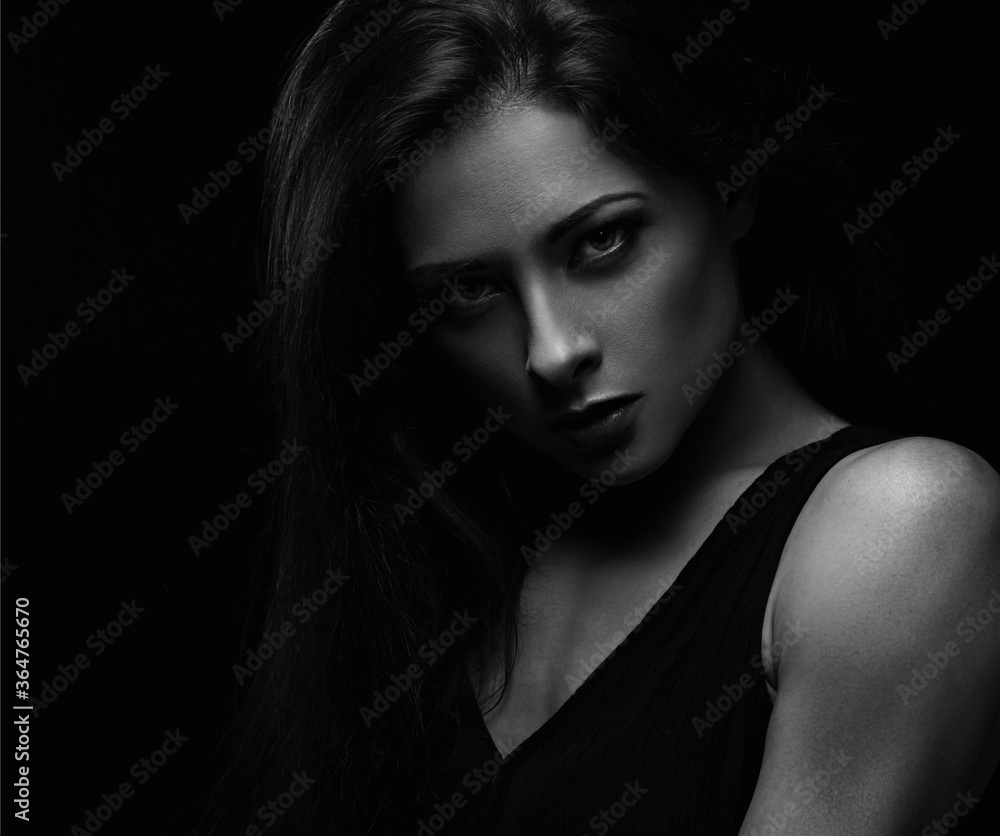 Beautiful makeup female model with long hair looking sexy on black background in darkness. Closeup portrait. Art.Expression portrait. Vogue.