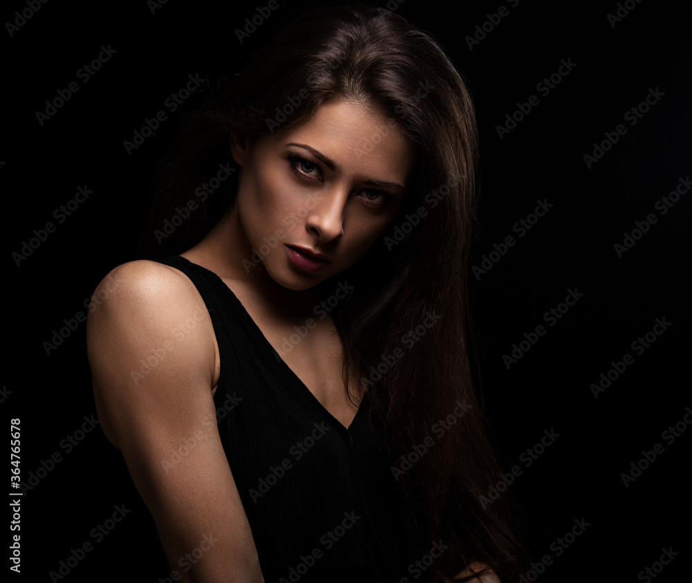 Beautiful makeup female model with long hair looking sexy on black background in darkness. Closeup portrait. Art Beautiful makeup female model with long hair looking sexy on black background in darkness. Closeup portrait. Art