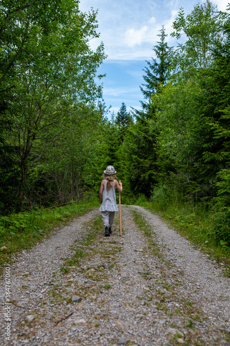 Kleines Mädchen wandert tapfer durch einen Wald