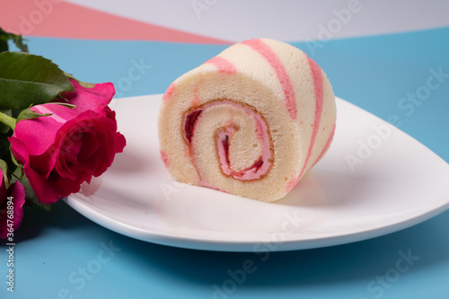 Strawberry swiss cream roll cake in dish with whipped cream