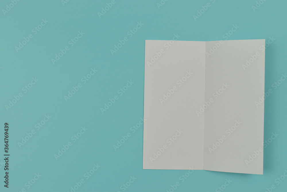 Two folded blank paper leaflet on blue background. Two folded blank paper leaflet on blue background.