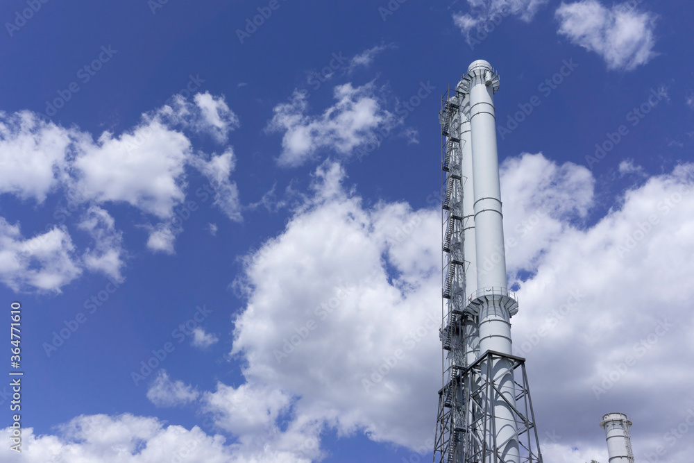 The observation tower on the blue background. Blue sky with clouds. Manufacture background. White tower on a blue background. Commercial texture. Factory view. The observation tower on the blue background. Blue sky with clouds. Manufacture background. White tower on a blue background. Commercial texture. Factory view.