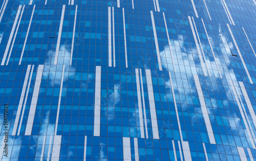 Interesting shot of the facade of the commercial building. Clouds reflections. Abstract commercial background. 