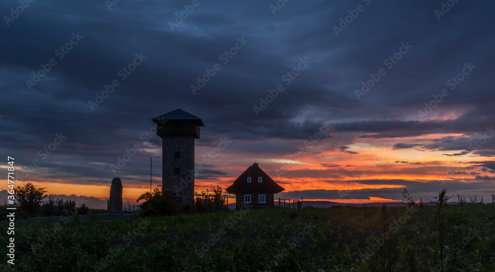 Sunset in summer rainy evening near Roprachtice village with observation tower Sunset in summer rainy evening near Roprachtice village with observation tower
