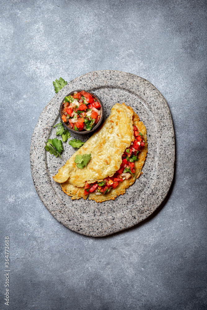 Big potato pancake with tomato sauce salsa on gray plate, gray background, top view Big potato pancake with tomato sauce salsa on gray plate, gray background, top view