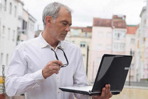 mature man using laptop computer close up view
