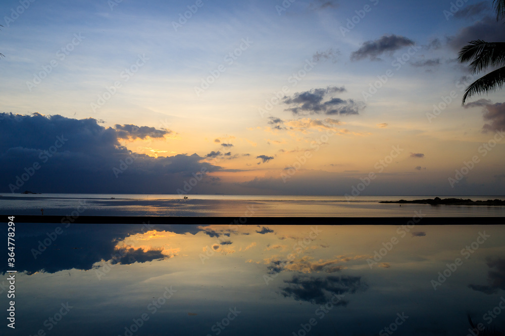 Obraz premium Blue and Orange sunset with a beautiful cloud reflexion over the water