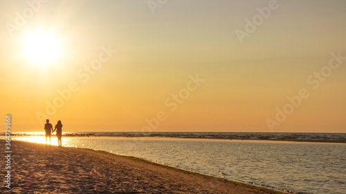 blurred couple silhouette of two people in love at sunset, relaxed man and women walking and enjoying sunset beauty