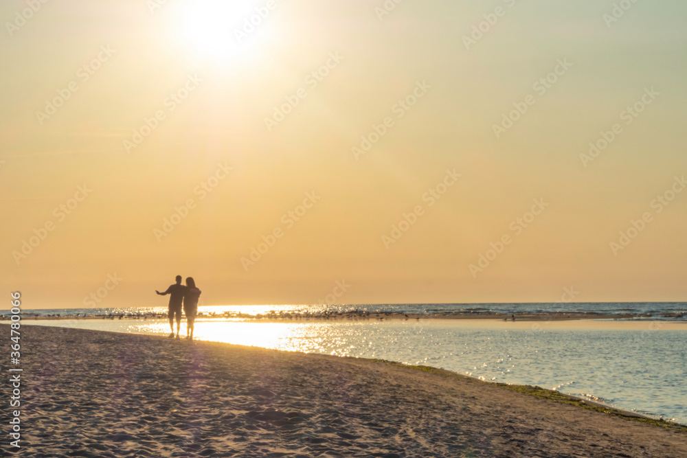 blurred couple silhouette of two people in love at sunset, relaxed man and women walking and enjoying sunset beauty