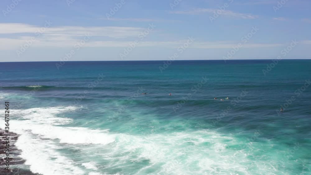 Aerial orbit view of group of surfers in rolling waves in Indonesia Aerial orbit view of group of surfers in rolling waves in Indonesia