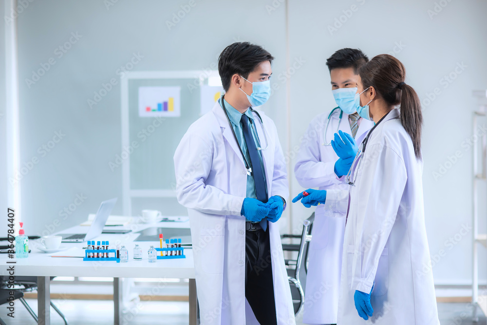The medical team Wearing uniform, gloves and mask is standing discussing about the blood sample of patients who have been infected the Covid-19 virus. That was treated with newly discovered vaccine The medical team Wearing uniform, gloves and mask is standing discussing about the blood sample of patients who have been infected the Covid-19 virus. That was treated with newly discovered vaccine