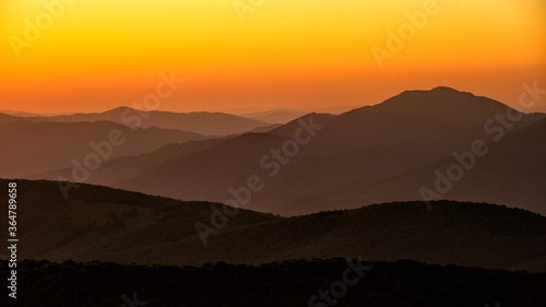Silhouettes of mountains against the backdrop of the setting sun. Wielka Rawka Mountain. The Bieszczady Mountains  Carpathians. Poland