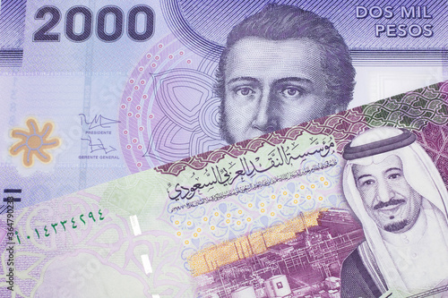 A purple two thousand peso bank note from Chile with A colorful five Saudi riyal bank note close up in macro photo