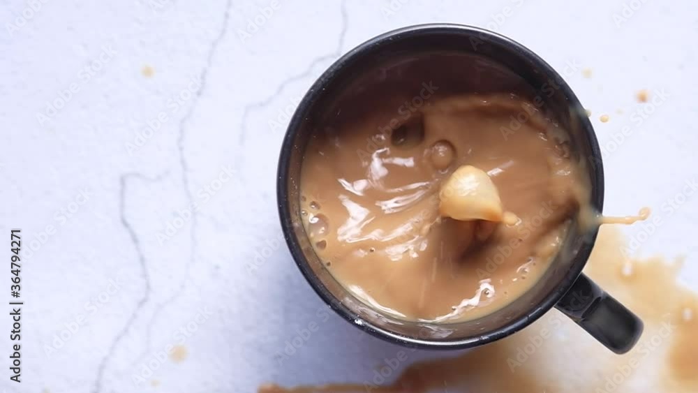 Top view of sugar cube falling into a coffee cup. Top view of sugar cube falling into a coffee cup.