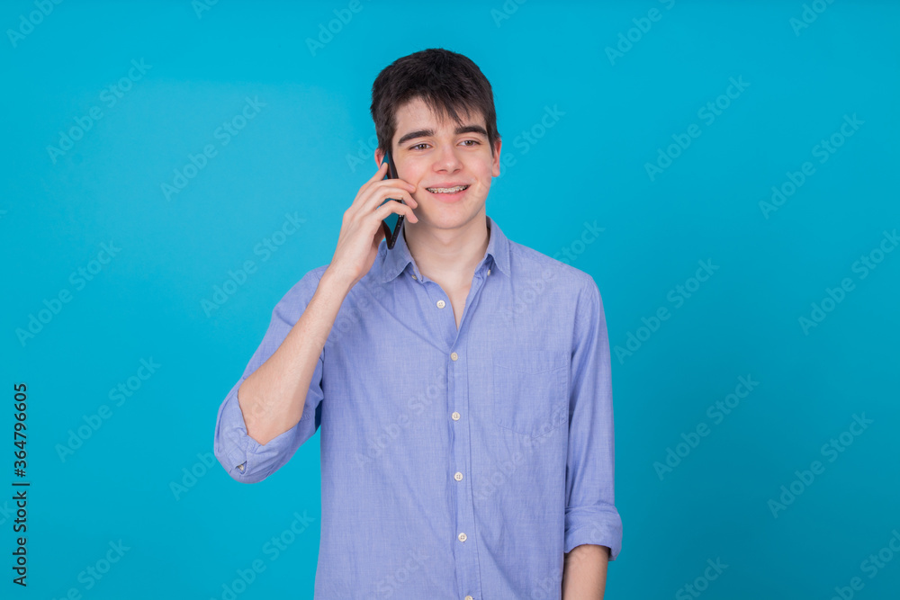 young male teenager with mobile phone isolated on background young male teenager with mobile phone isolated on background